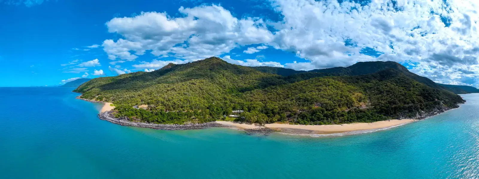 Panoramic aerial view of the rainforest headland meeting the Coral Sea