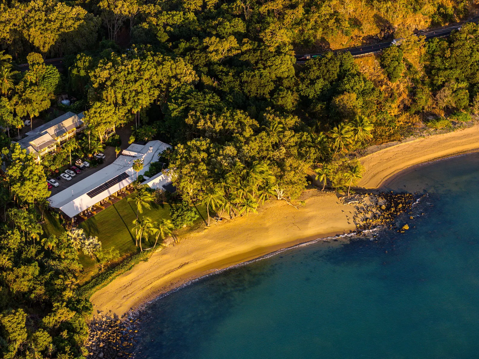 Aerial view of Turtle Cove Beach Resort set in rainforest behind its own beach