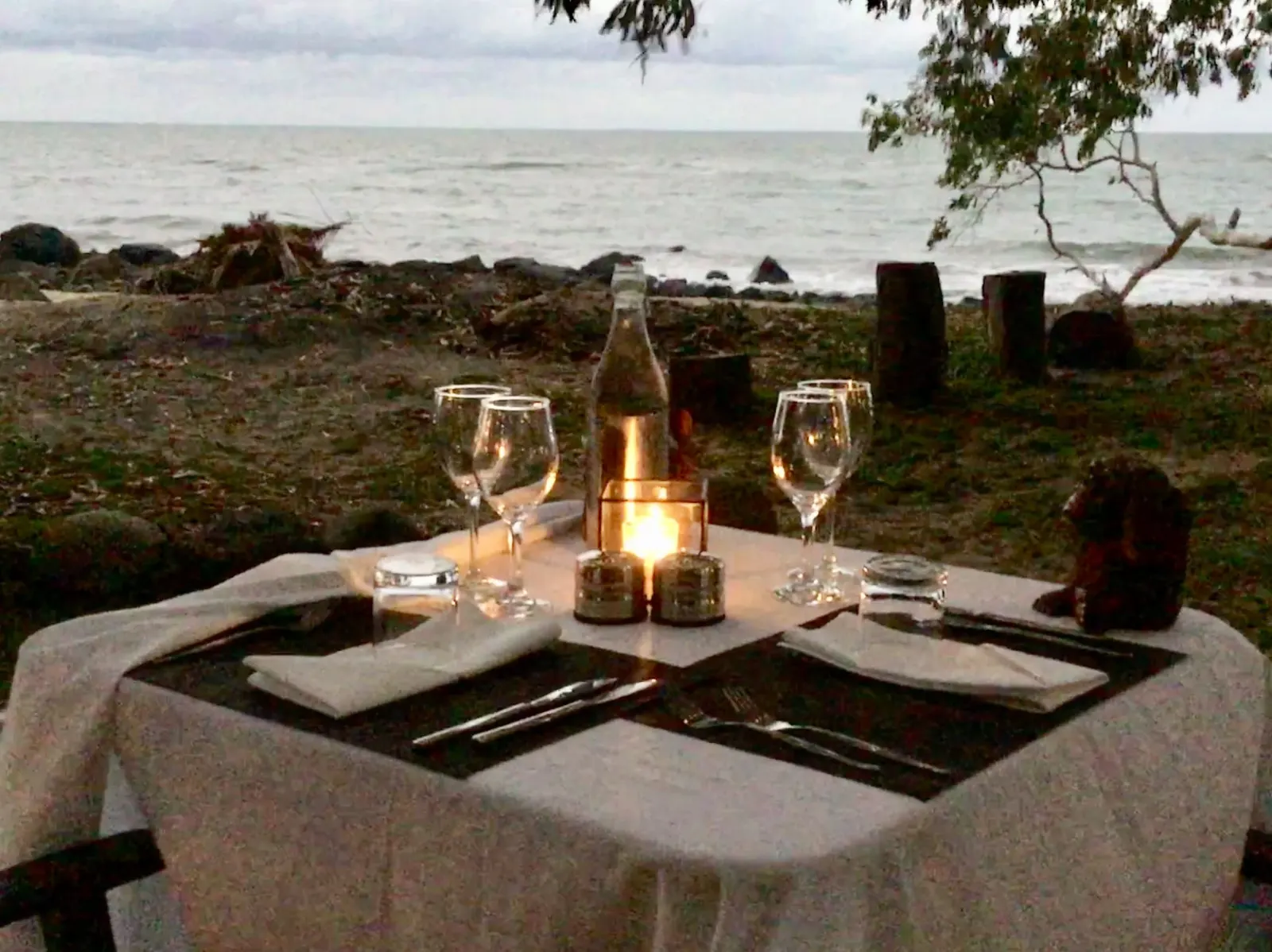 A table set for dinner on the beach at dusk